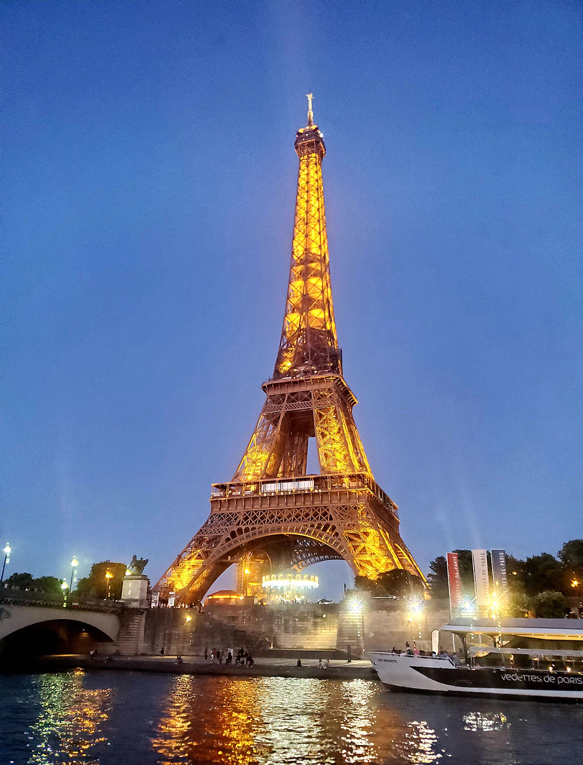 The Eiffel Tower in Paris, France lit up during dusk.