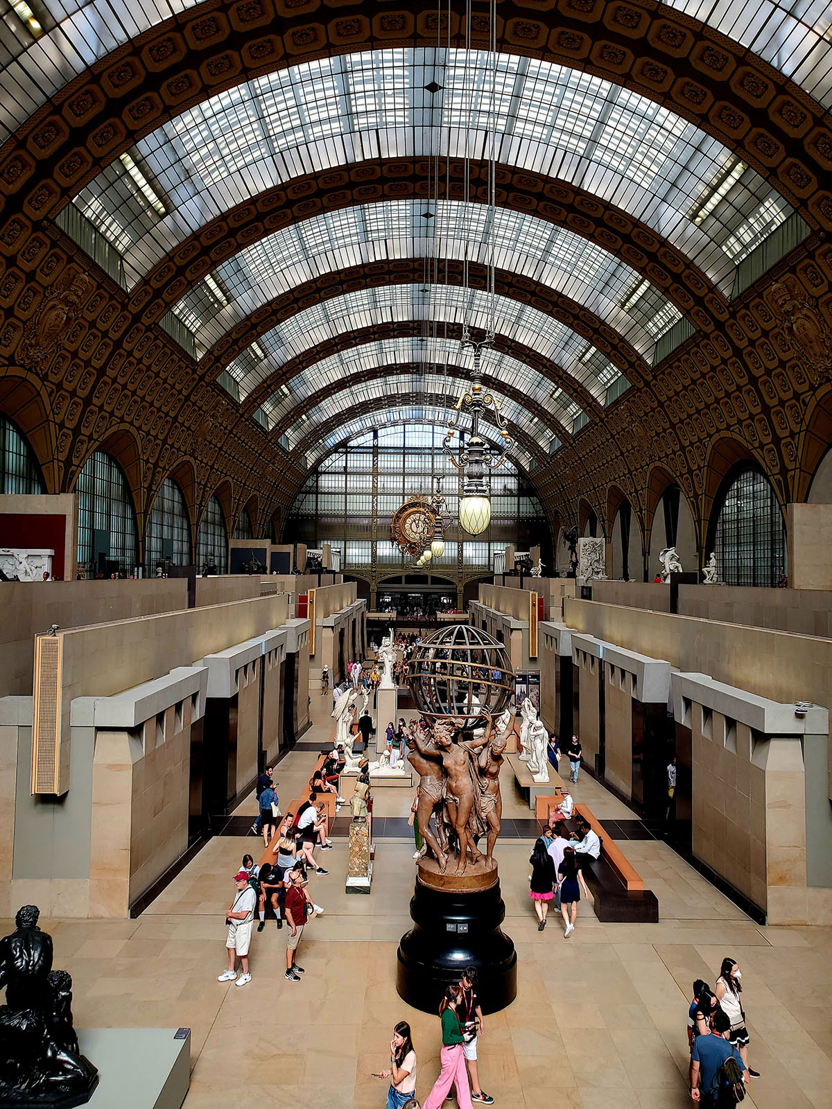 Inside the Musée d’Orsay with people wondering around looking at various sculptures.