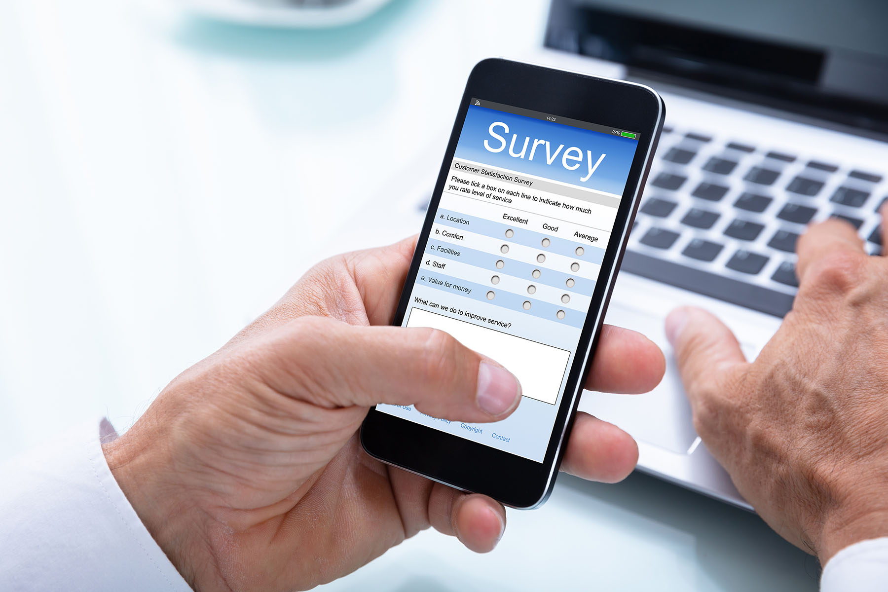 A man's hand holding a phone. On the phone's screen, it says "Survey" with a sample question from a customer satisfaction survey. 