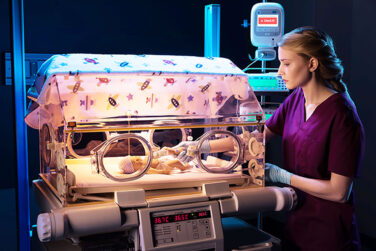A nurse applying the ivWatch to a baby in a neonatal intensive care unit